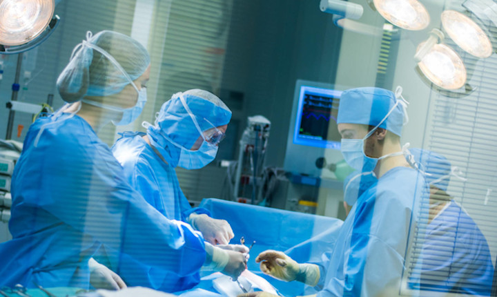 Team of four surgeons working in a hospital operating theater