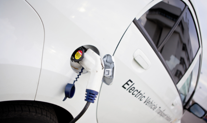 A white electric vehicle being recharged