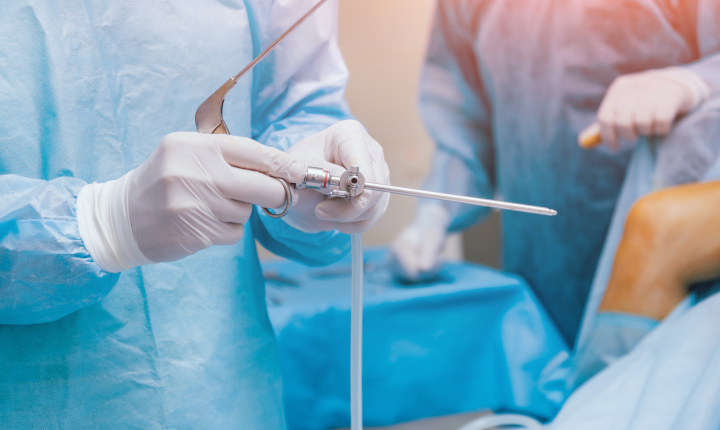 Doctor holding a medical instrument in a hospital operating theater