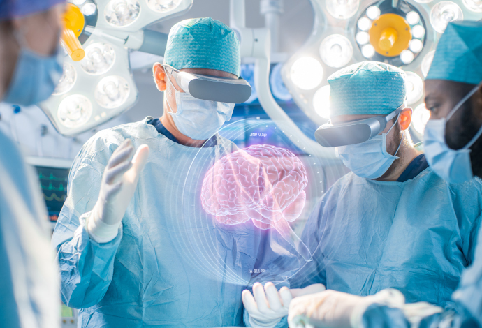 Team of surgeons with smart glasses looking at an augmented reality image of a brain