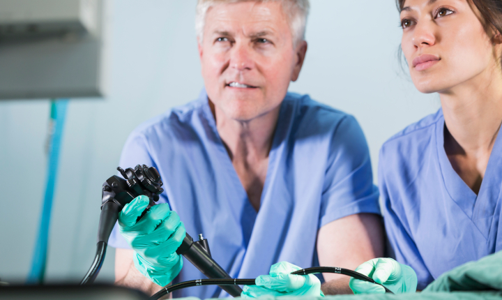 Doctor holding large endoscope in hospital operating theater