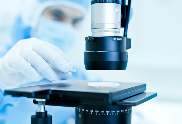 Scientist placing sample underneath imaging equipment in a laboratory