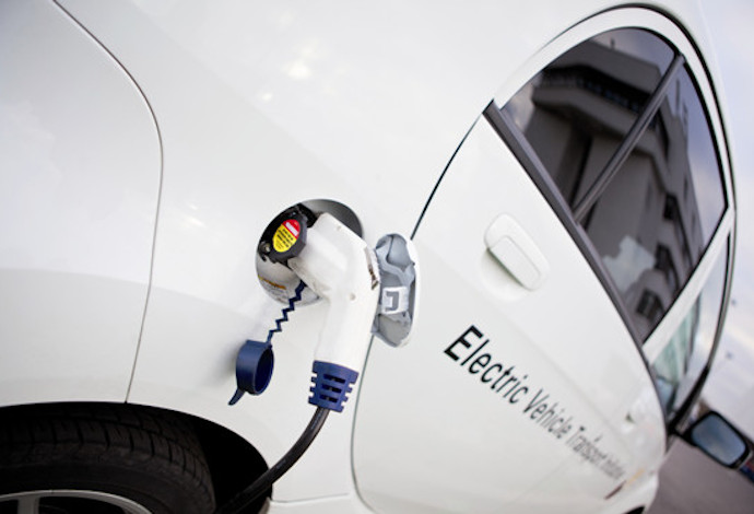 A white electric vehicle being recharged 	