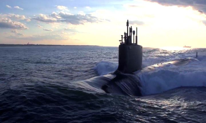 Submarine emerging from the sea with sunrise background