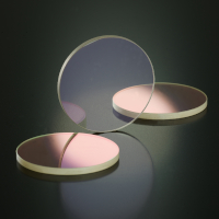 Three clear discs of SCHOTT Multispectral ZnS glass with an anti-reflective hard coating on a black background