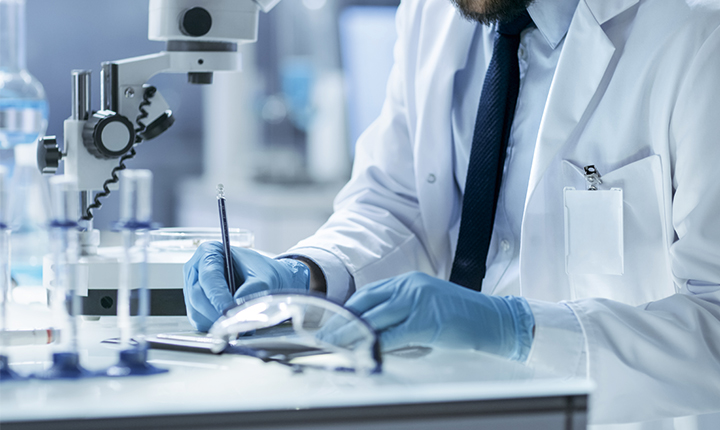 Research scientist in a laboratory writing down experiment observations