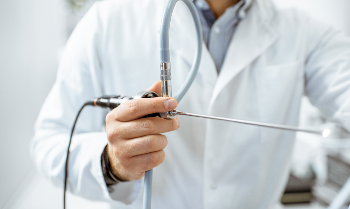 Male surgeon behind a series of endoscopes in a hospital operating theater