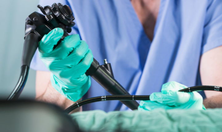 Surgeon in hospital operating theatre holding an endoscope	