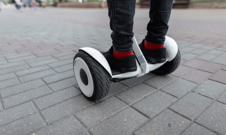 Two feet with red socks standing on a white hoverboard
