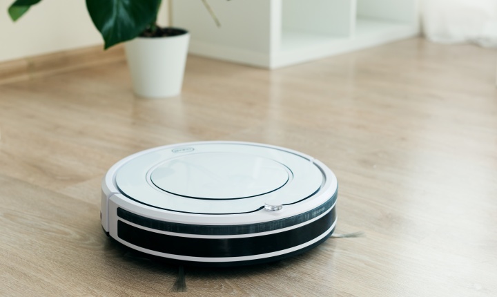 White robotic vacuum cleaner on wooden floor