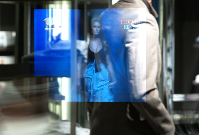 Semi-transparent mirrored image of a woman with male in the foreground in a display made from SCHOTT MIRONA® glass	
