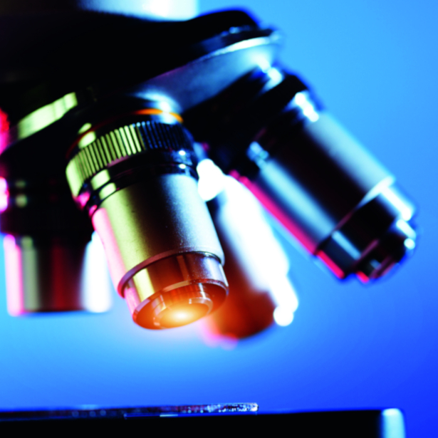 Close up of four microscope lenses on a blue background