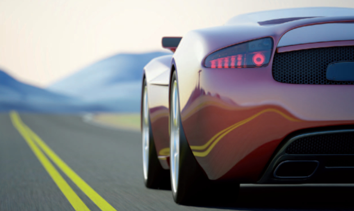 Red sports car driving down a clear road