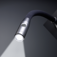 Small, circular, silver Opal Round reading light for aircraft cabins by SCHOTT