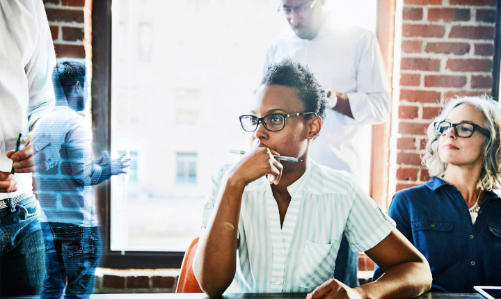 Two females in a conference room watching a augmented reality presentation