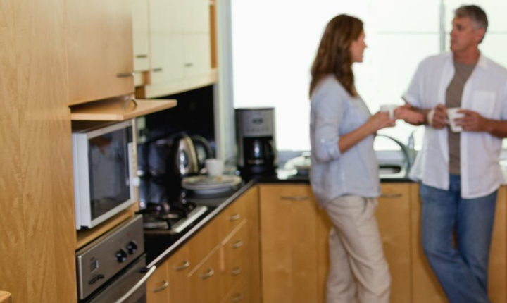 Man and woman talking in a home kitchen