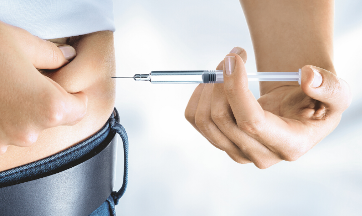 A woman injecting herself with medication using a syringe