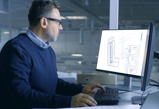 Middle aged man working on computer in factory office