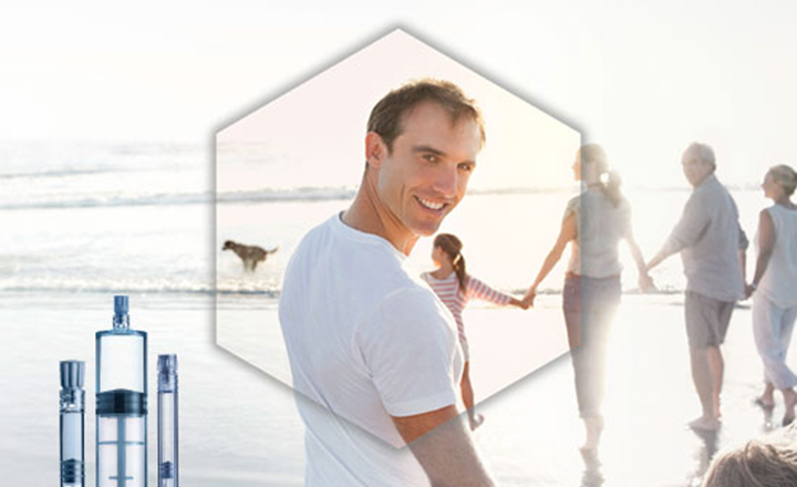 Man looking to camera on a beach surrounded by family