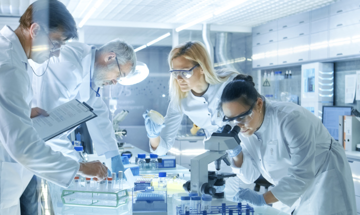 Four scientists in a laboratory performing analysis