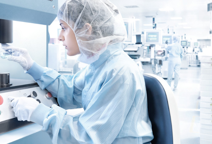 Scientist looking at a clear pharmaceutical glass vial made by SCHOTT