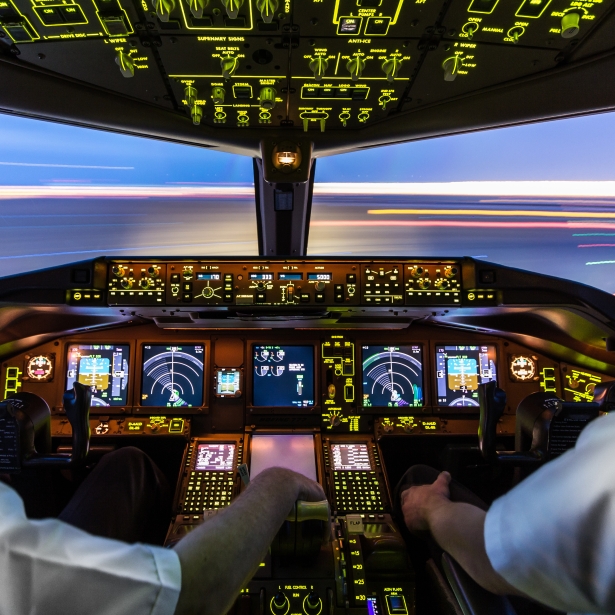 Interior of an aircraft cabin with illuminated controls and displays