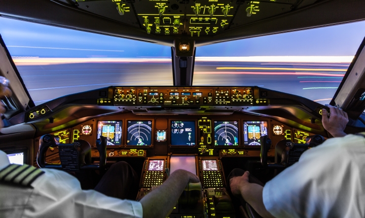 Interior of an aircraft cabin with illuminated controls and displays