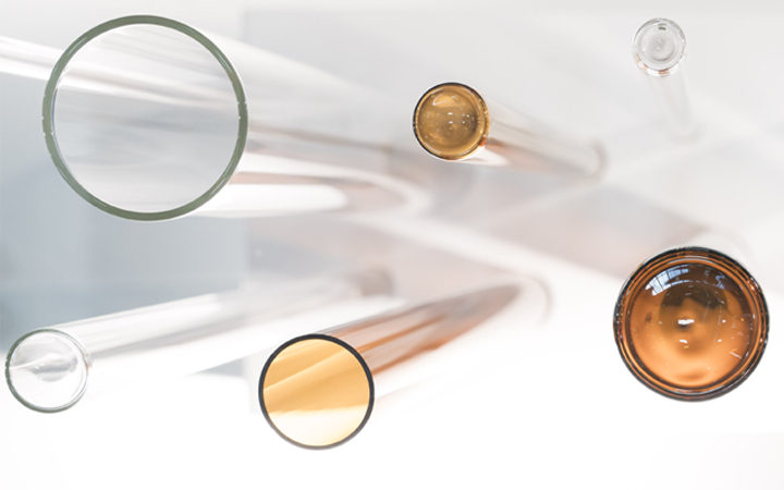 Grand tube en verre transparent avec un tube en verre ambré plus petit fabriqué par SCHOTT pour l’industrie pharmaceutique