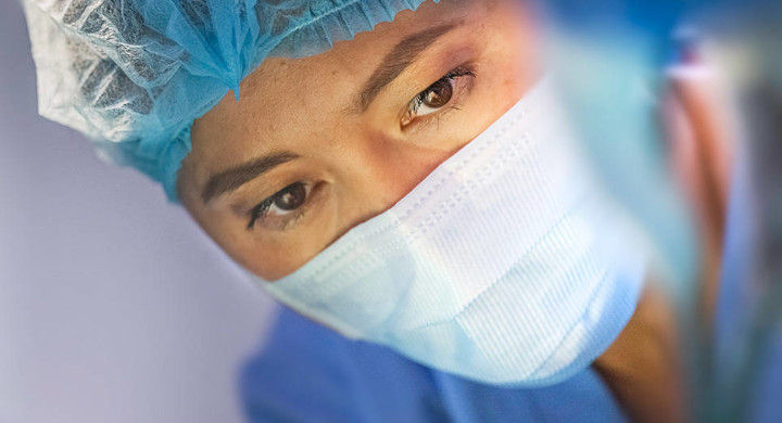 SCHOTT provides components for a wide range of medical equipment Female surgeon looking at a patient in a hospital operating theatre