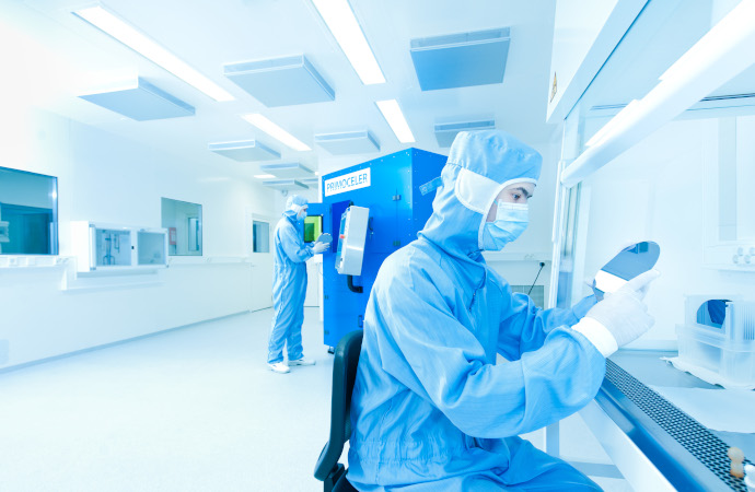 Scientist working in a laboratory inspecting a glass wafer