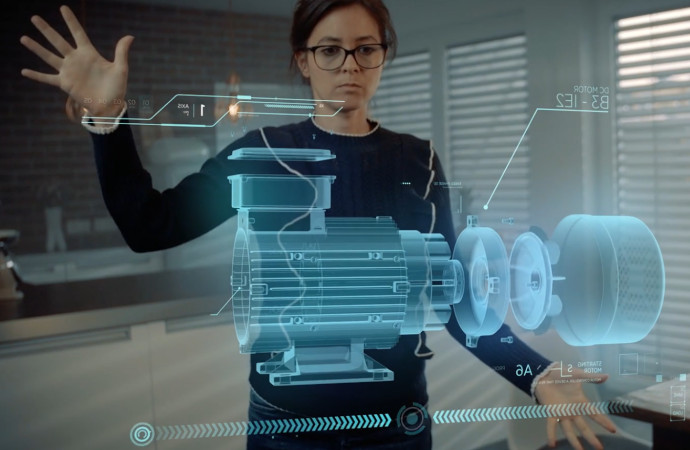 Young woman standing in front of augmented reality image of a machine component