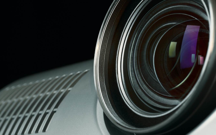 Close up of a projector lens with reflected colors