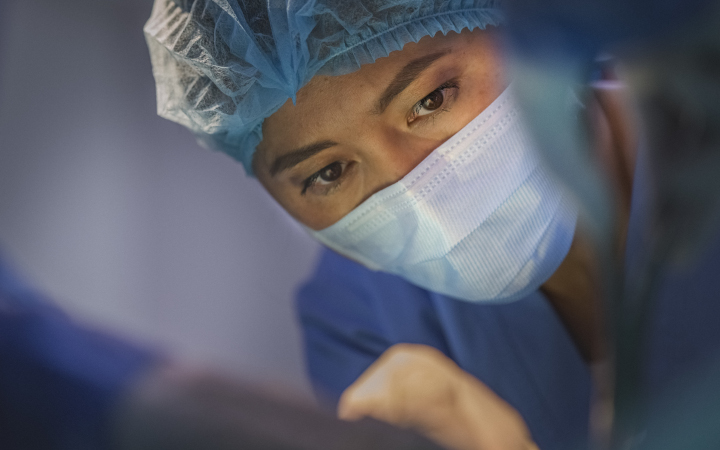 Female surgeon looking at a patient in a hospital operating theatre