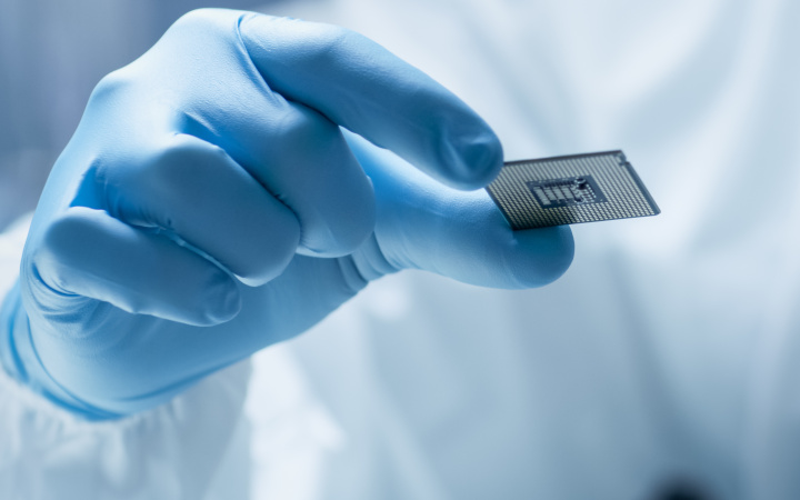 Gloved hand holding a glass slide in a research laboratory