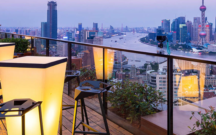 Rooftop bar looking out over a city lit by table lights