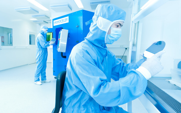 Two scientists working in a laboratory looking at mirror discs