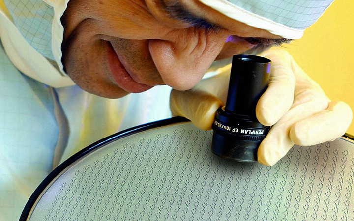 Scientist inspecting a large glass wafer