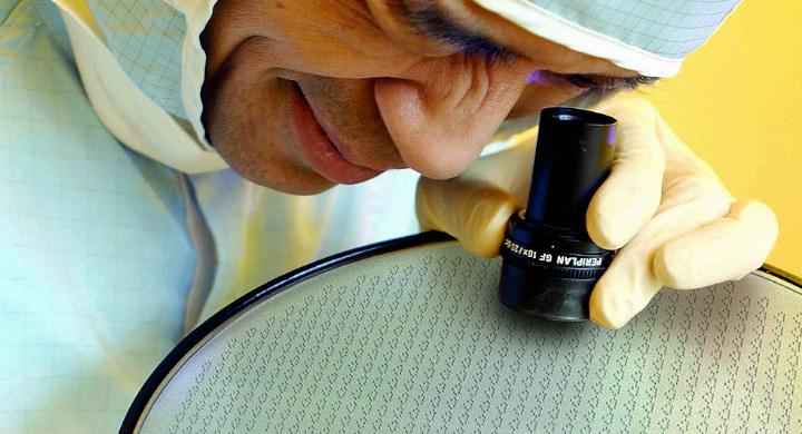 SCHOTT has a large amount of experience in the glass wafer sector Scientist inspecting a large glass wafer