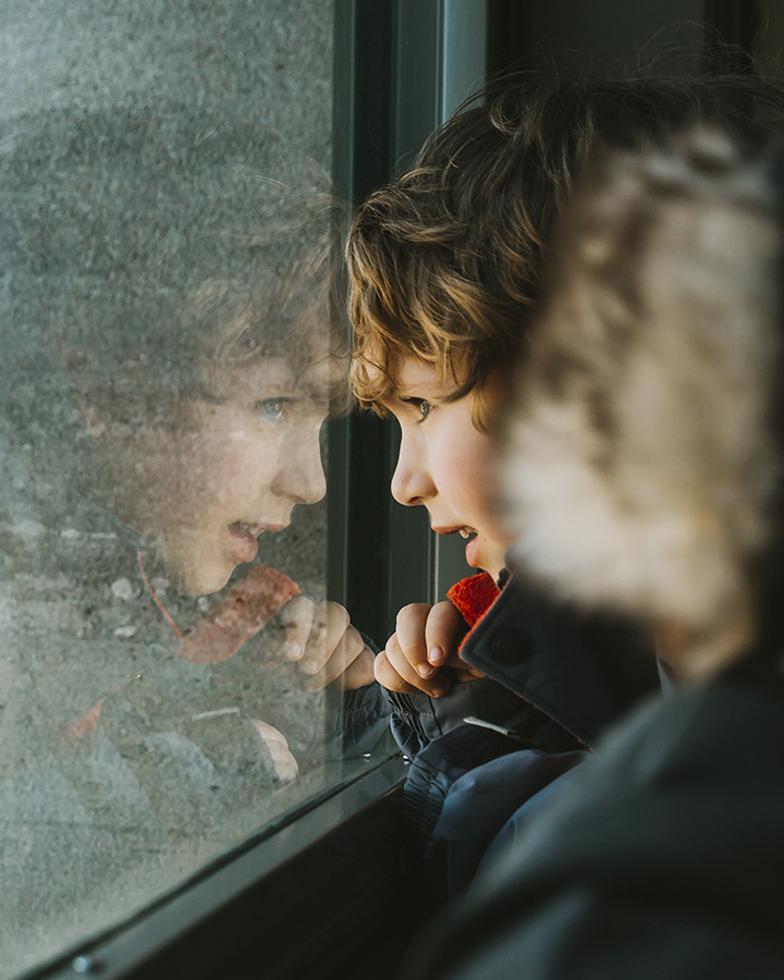 SCHOTT specialty glass products offer precision, purity, flexibility and strength Small boy looking out of glass window onto city below